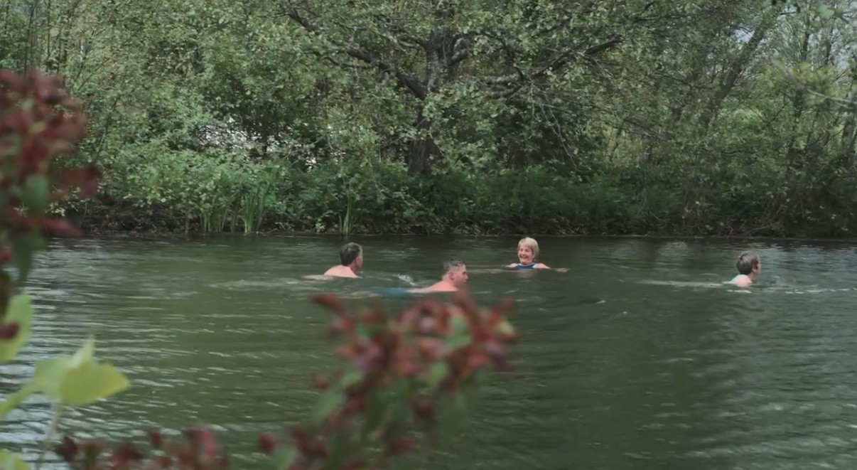 Spring-fed wild swimming lake at Secret Valley wellness retreat in Somerset