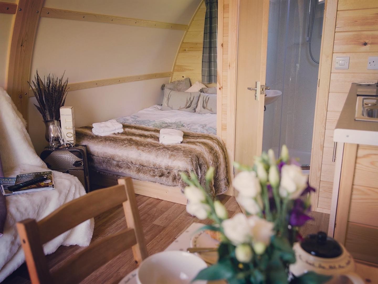 Lodge interior with luxury bedding and fresh flowers